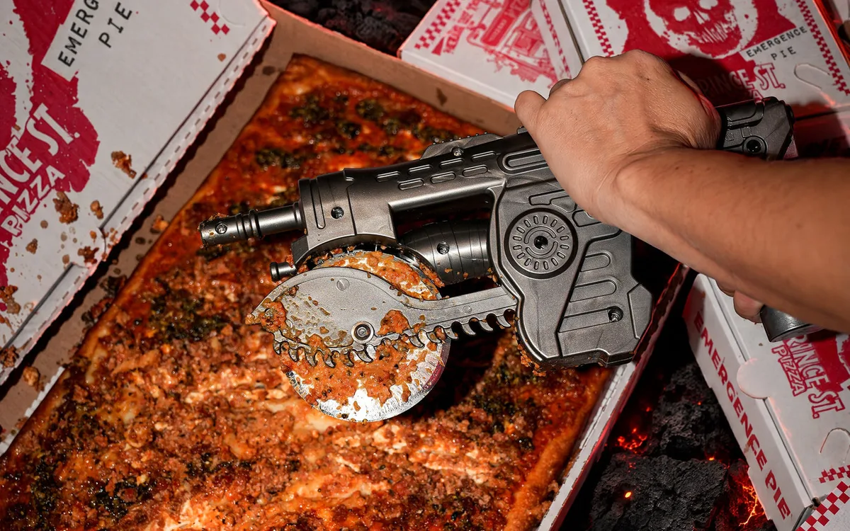 The Lancer pizza cutter slicing an Emergence Pie, surrounded by Gears of War E-Day pizza boxes